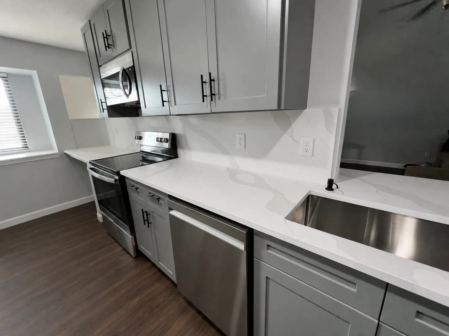 Soft-veined white quartz counters and stainless appliances